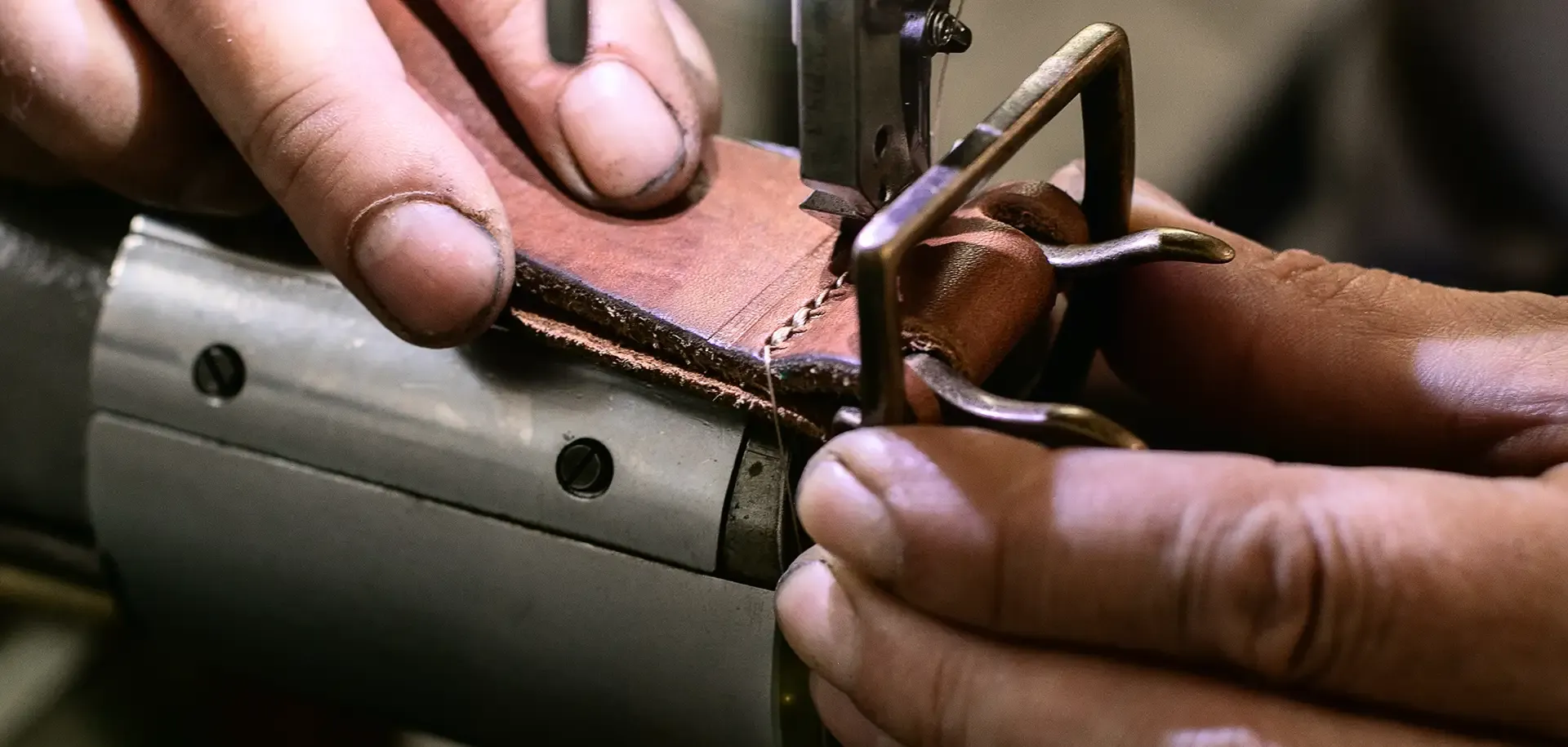 A photo of Andreas, the owner of Cinturificio Balzani, sewing one of their Italian artisanal belts.