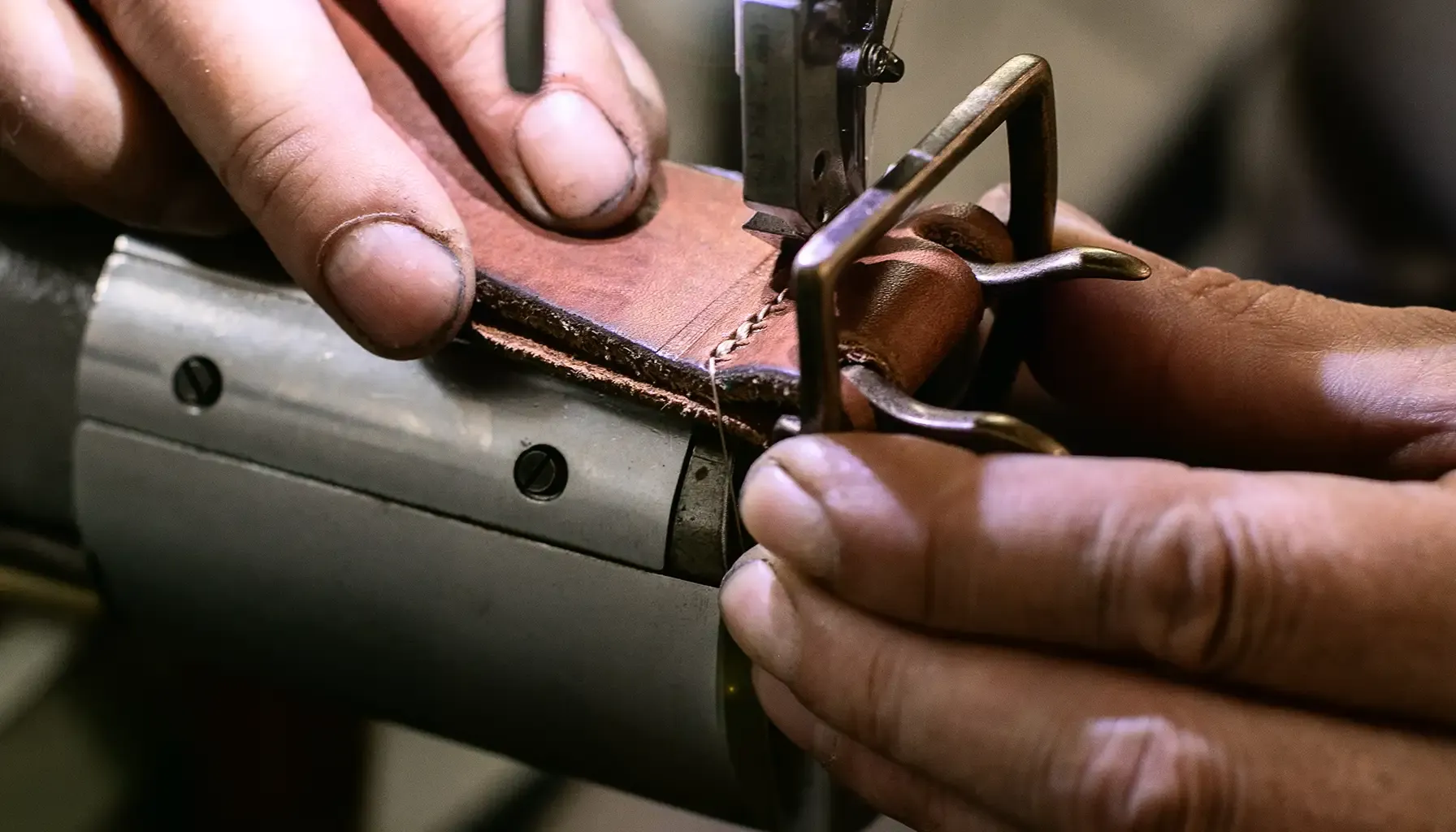A photo of Andreas, the owner of Cinturificio Balzani, sewing one of their Italian artisanal belts.